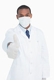 Portrait of male doctor in mask gesturing thumbs up