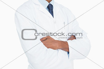 Close up mid section of a male doctor with arms crossed