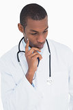 Serious thoughtful male doctor looking down