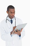 Serious male doctor writing on clipboard