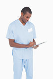 Serious male surgeon writing on clipboard