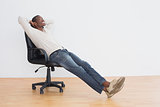 Thoughtful casual Afro man sitting on office chair in empty room