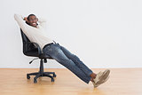 Casual Afro young man sitting on office chair in an empty room