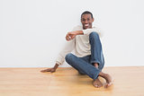 Afro young man sitting on floor in an empty room