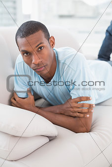 Portrait of a relaxed Afro man lying on sofa