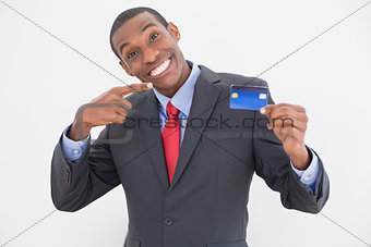 Cheerful young Afro businessman pointing at credit card