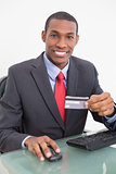 Smiling Afro businessman doing online shopping