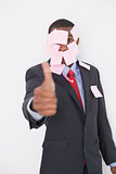 Afro businessman covered in blank notes gesturing thumbs up