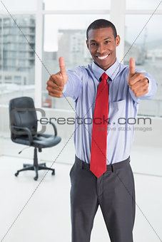 Elegant Afro businessman gesturing thumbs up in office