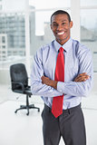 Elegant smiling Afro businessman standing in office