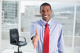 Elegant smiling Afro businessman offering handshake at office
