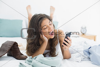 Woman shouting into mobile phone in bed