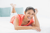 Cheerful young woman lying in bed