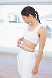 Woman measuring waist in fitness studio