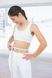 Woman measuring waist in fitness studio