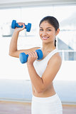 Woman exercising with dumbbells in fitness studio