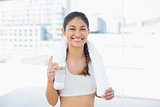Woman with towel around neck holding water bottle