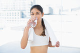 Woman with towel around neck drinking water