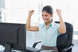 Happy businesswoman looking at computer in office