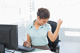 Happy businesswoman in front of computer in office