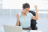 Happy businesswoman in front of laptop in office
