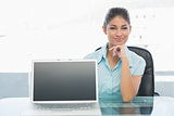 Elegant businesswoman displaying laptop on desk in office