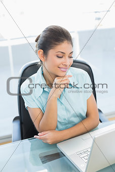 Elegant businesswoman using laptop at office