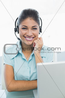 Businesswoman wearing headset in front of laptop