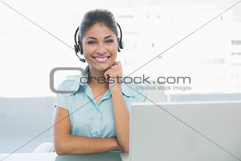 Businesswoman wearing headset in front of laptop