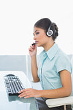 Businesswoman wearing headset while using computer