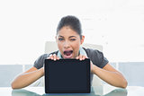 Bored businesswoman displaying tablet PC in office