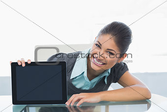 Portrait of smiling businesswoman displaying tablet PC