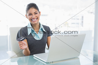 Portrait of a smiling businesswoman doing online