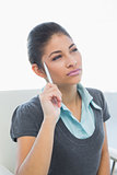 Thoughtful businesswoman holding pen in office