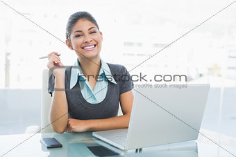Smiling businesswoman with laptop at office