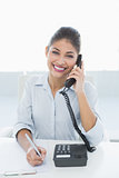 Portrait of an elegant businesswoman using telephone at desk
