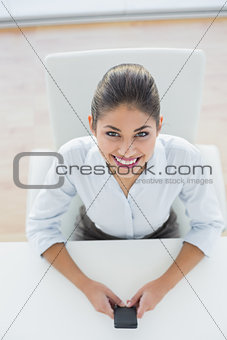 Portrait of businesswoman text messaging in office