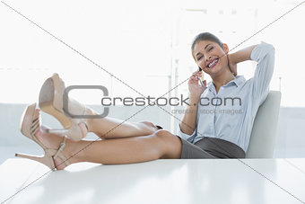 Relaxed businesswoman using cellphone in office