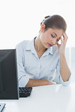 Businesswoman suffering from headache in front of computer