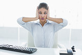 Businesswoman suffering from headache in front of computer at office