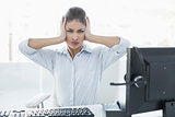 Businesswoman suffering from headache in front of computer