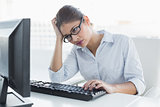 Tensed businesswoman with computer in office