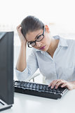 Tensed businesswoman with computer at office