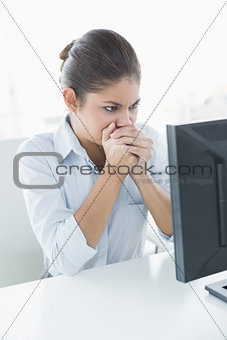 Serious businesswoman looking at computer in office