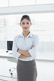 Elegant businesswoman with arms crossed in office