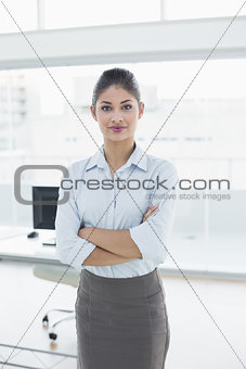 Elegant businesswoman with arms crossed in office