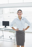 Elegant businesswoman with hands on hips in office