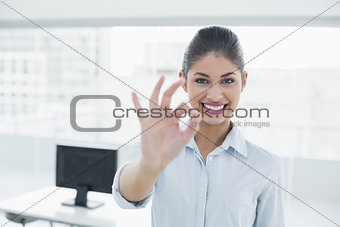 Businesswoman gesturing ok sign in office