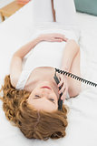 Relaxed woman using telephone in bed