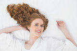 Overhead portrait of a smiling young blond in bed